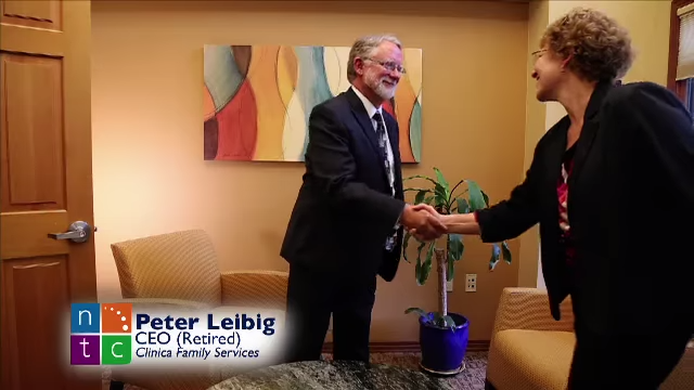 Image from the Primary Care Partnership Video of a middle-aged man and woman in a cozy office shaking hands.